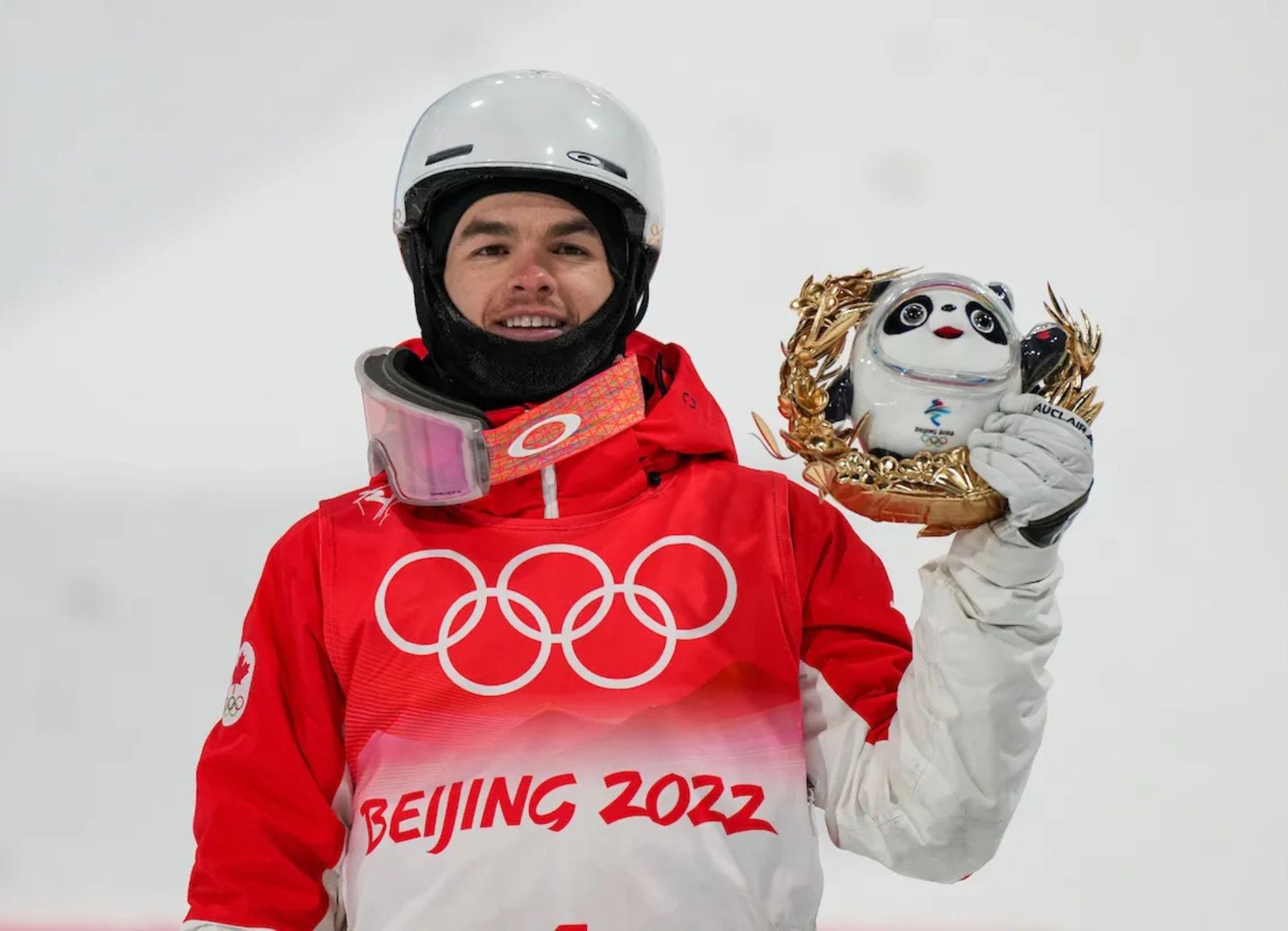 Canadian freestyle skier Mikaël Kingsbury holds the Beijing 2022 Winter Olympics mascot after winning silver in the men's moguls competition.