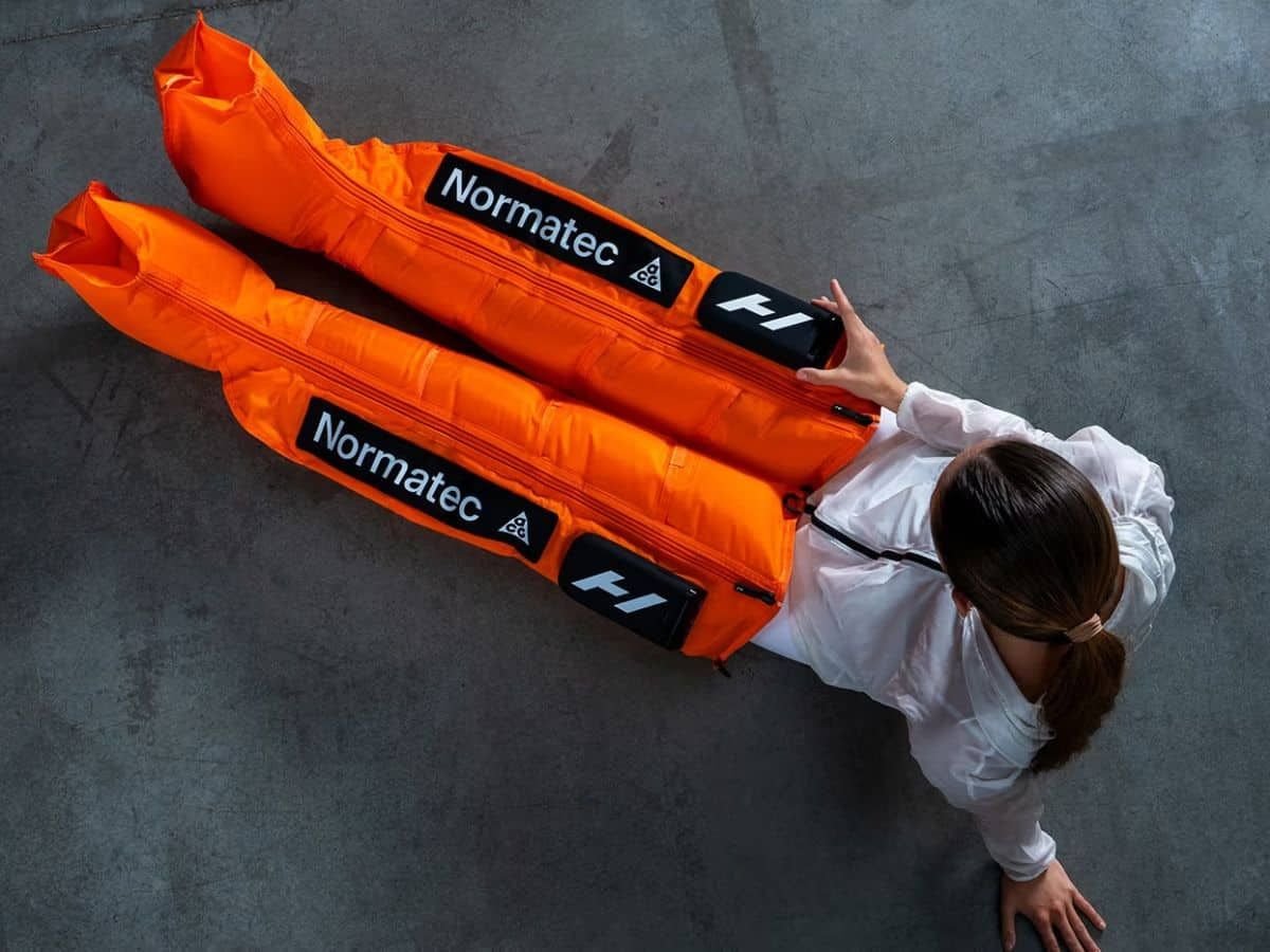 Overhead view of the orange Hyperice x Nike ACG Normatec Elite recovery system. 