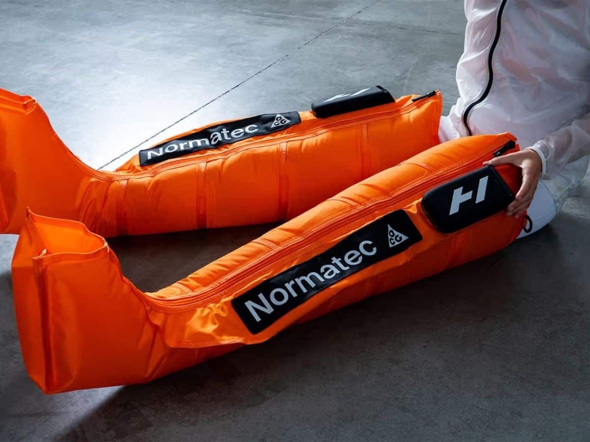Hyperice x Nike ACG co-branded orange Normatec Elite recovery sleeves.