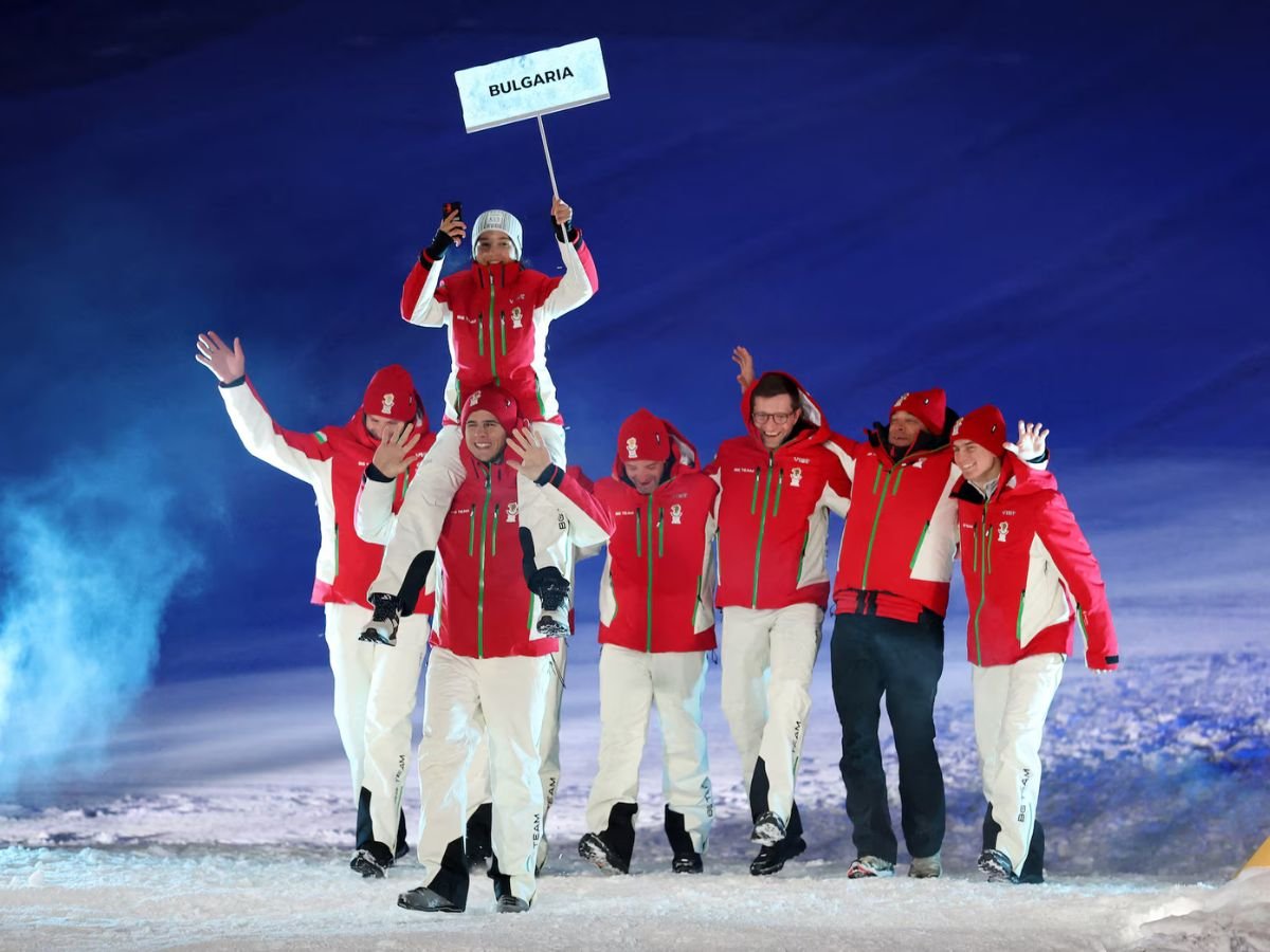 Team Bulgaria parades during the Milano Cortina 2026 Winter Olympics opening ceremony, with one athlete carrying the delegation's sign while riding on a teammate's shoulders.