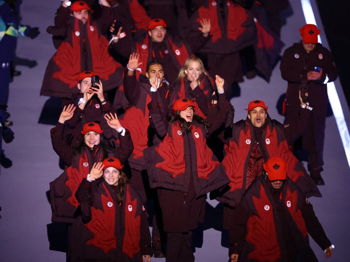 Team Canada parades at the Milano Cortina 2026 Winter Olympics opening ceremony, with athletes in maple-leaf-themed uniforms waving to the crowd.